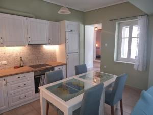 a kitchen with a glass table and blue chairs at Andros house in Andros