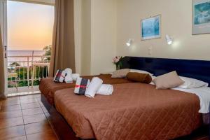 a bedroom with a large bed with a view of the ocean at Beach Oasis by BS- in Agios Gordios +36 photos