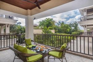 a patio with chairs and a table on a balcony at Deshco Oasis Suites, Alibaug in Chorondpāda