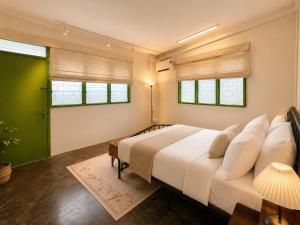a bedroom with a large bed and two windows at Arvena Living in Jelutong