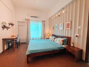 a bedroom with a bed and a table and a desk at Deshco Oasis Suites, Alibaug in Chorondpāda