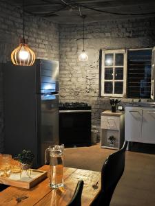 a kitchen with a wooden table and a refrigerator at Suíte cine centro in Garanhuns