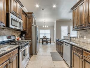 a kitchen with stainless steel appliances and a table at Unpack and Unwind in Yukon