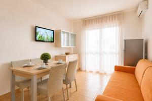 a kitchen and dining room with a table and chairs at Residence Columbia in Bibione