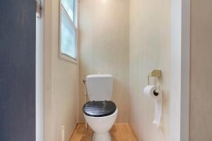a bathroom with a toilet with a black seat at 22.Mobil-home option clim 5pers in Calviac +36 photos