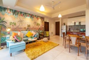 a living room with a blue couch and a kitchen at Deshco Oasis Suites, Alibaug in Chorondpāda