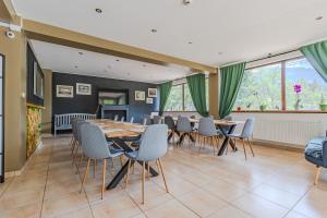 a dining room with tables and chairs and windows at Casa Vlasin in Poiana Brasov