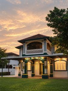 a house with a sunset in the background at Arvena Living in Jelutong