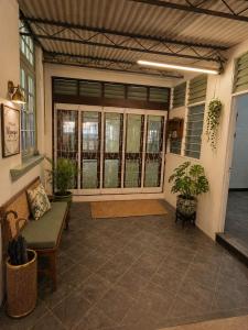 a screened in porch with a bench and plants at Arvena Living in Jelutong +1 photo