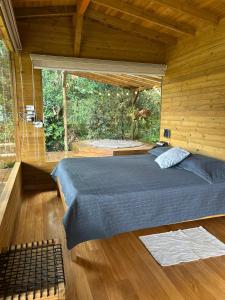 a bedroom with a bed and a large window at MAGDA Nature Lodge in El Retiro