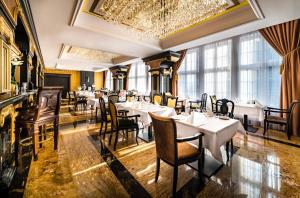 a restaurant with tables and chairs and a chandelier at Hanza Tower Sky Lux 17th floor in Szczecin