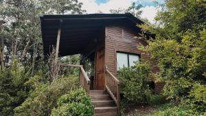 a wooden cabin with stairs leading to a window at MAGDA Nature Lodge in El Retiro +8 photos