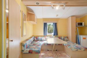 a small room with a couch and a table at 21.Mobil-home option clim-5 pers in Calviac