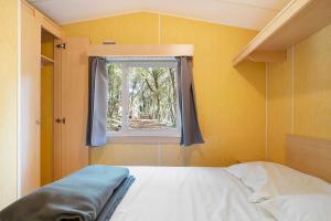 a bedroom with a bed and a window at 21.Mobil-home option clim-5 pers in Calviac +29 photos