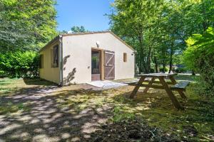 a picnic table in front of a tiny house at 10. cerisiers option clim- 4 pers in Calviac