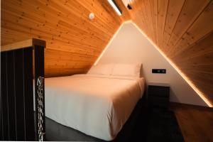 a bed in a room with a wooden ceiling at NOE Suites in Ayios Theodhoros