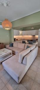 a large living room with white couches and tables at Andros house in Andros