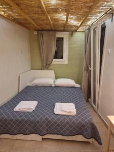 a bed in a room with two towels on it at Andros house in Andros +3 photos