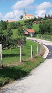 a road with a fence and a building on a hill at Casa Rotti - Countryside Retreat near Krško in Krško +7 photos