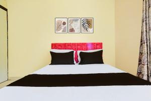 a bedroom with a bed with a red headboard at Hotel O Paradise Green in Indore
