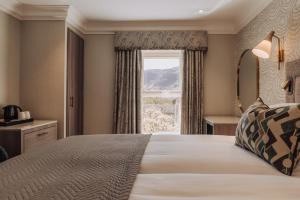 a bedroom with a large bed with a window at The Borrowdale Hotel in Keswick