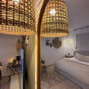 a bedroom with two large wicker chandeliers and a bed at Bali island Studio in Al Khobar