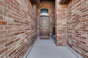 a door in a brick building with a sidewalk at A Serene Oasis! 4-bedrooms! in Saginaw