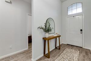 a hallway with a mirror and a table with a mirror at A Serene Oasis! 4-bedrooms! in Saginaw