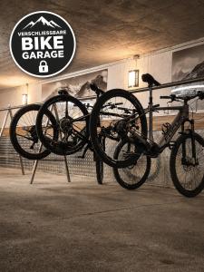 Zwei Fahrräder stehen auf einem Fahrradständer in einer Garage. in der Unterkunft Hotel Tannenberg in Saalbach-Hinterglemm