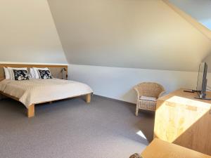 ein Schlafzimmer mit Bett, Fernseher und Stuhl in der Unterkunft Hotel Sanvilla in Sigulda