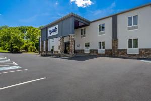 a large white building with a parking lot at Spark by Hilton Milford Boston in Milford