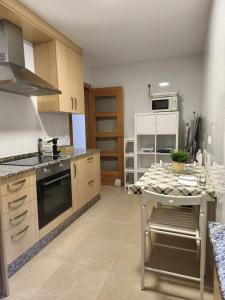 a kitchen with a stove and a table in it at Piso en Cedeira in Cedeira