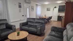 a living room with couches and a table and a kitchen at Krka Hideaway in Lozovac