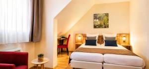 a hotel room with a bed and a red chair at A l'Arbre Vert in Wintzfelden