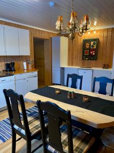 a kitchen with a wooden table with chairs and a dining room at Toppastranda 20 in Sør-Fron +3 photos
