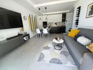 a living room with a gray couch and a kitchen at Sul Mare in Molfetta