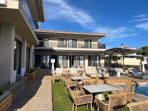 a patio with tables and chairs and a pool at SunSet Boutique Hotel in Neos Marmaras