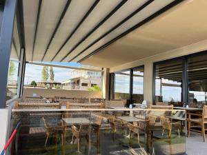 a restaurant with tables and chairs and windows at SunSet Boutique Hotel in Neos Marmaras