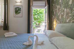 two swans sitting on a bed in a bedroom at In Centro a Rho Fiera Milano e Ospedale Galeazzi in Rho