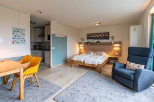 a bedroom with a bed and a table and chairs at Appartementencomplex Juliana 68 in De Koog