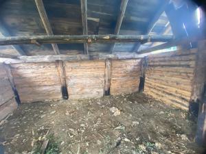 an inside view of a barn with wooden walls at Osada Słowiańska in Chyrowa