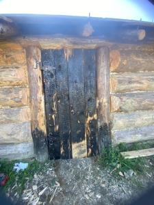a wooden door on the side of a log cabin at Osada Słowiańska in Chyrowa