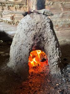 a stone oven with a fire in it at Osada Słowiańska in Chyrowa