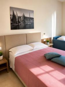 a bedroom with a large bed with a pink blanket at B&B LE MAGNOLIE in Termoli