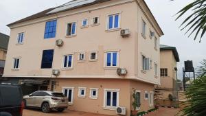 a building with a car parked in front of it at Clover Apartments and suites in Abuja
