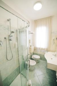 a bathroom with a shower and a toilet and a sink at Hotel Park in Sottomarina +93 photos