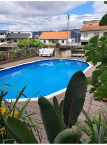 a large blue swimming pool in a yard at Casa do Centro - Alojamento Local in Vieira do Minho