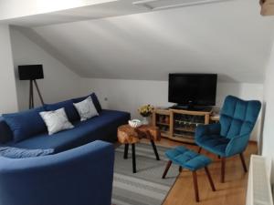 a living room with blue couches and a tv at Nika in Ogulin