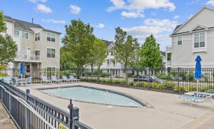 a swimming pool with chairs and a fence at WYJEK Stays - Riverside Haven in Cambridge