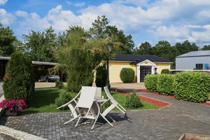 two white chairs sitting on a patio in front of a house at Boutique Hotel Ukus in Tešanj